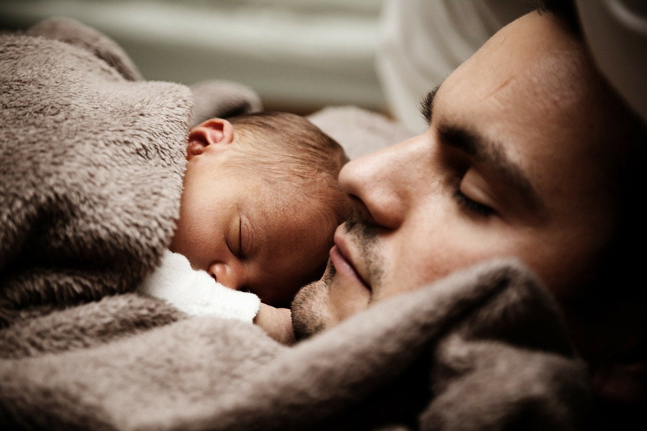 nyfødt sover på fars bryst - closeup